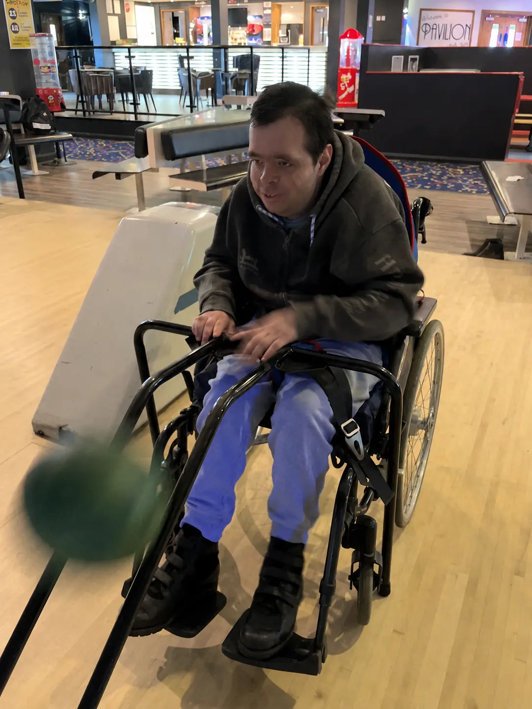 A participant enjoying a game of bowling on a community outing